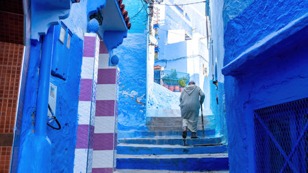 Chefchaouen, Morocco - 11 September 2022: Old man walking in Chefchaouen, known as the blue city, famous for its striking blue color painted medina buildings and streetsのeditorial素材