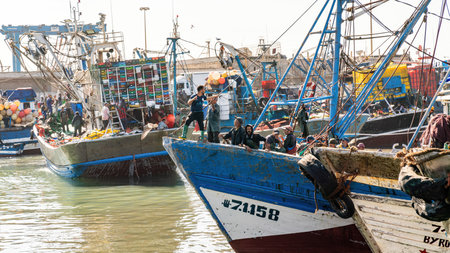 Essaouira, Morocco - 17 September 2022: Fishermen on a traditional blue fishing boat returning from sail and bringing in the day's catch to port of Essaouiraのeditorial素材