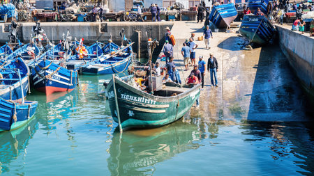 Essaouira, Morocco - 17 September 2022: Fisherman landing the fishing boat to the sea for its first sail at the port of Essaouira.のeditorial素材