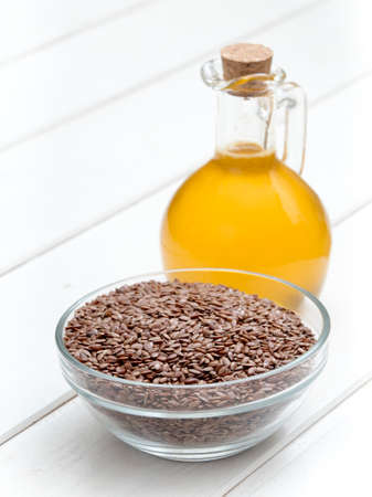 Flaxseed (linseed) oil in a bottle on white wooden backgroundの写真素材