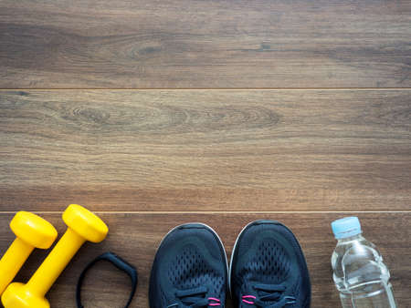 Healthy lifestyle concept on dark wooden background. Sports equipments top view with copy space