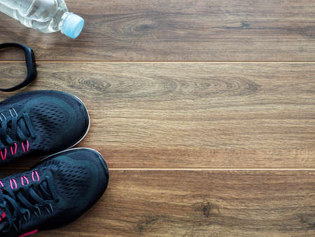 Running equipment over wooden background, top view