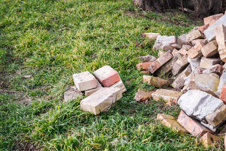 A pile of old used bricks with scratches and cracks from the old wall near the plot.の写真素材
