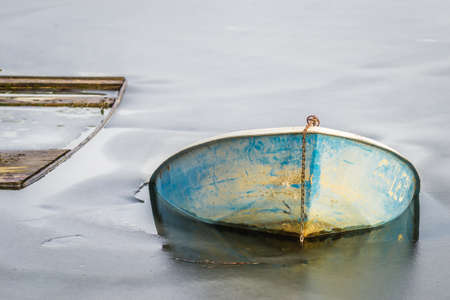 Submerged fishing boat in frozen water.の写真素材