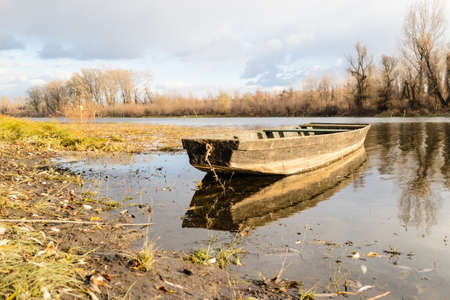 Moored wooden fishing boats on the banks of the Danube tributary.