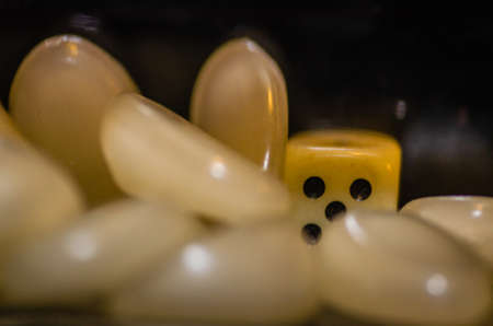 White plastic Iambic Cube in a glass bottle, surrounded by plastic stones.の写真素材