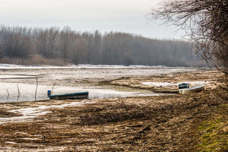 Wooden boats forgotten in the frozen water of the pond.の写真素材