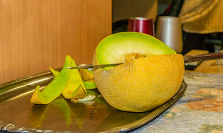 Open Melon fruit on a metal tray. Pulp of a melon. Internal part of a melon - her heart. an...