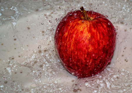 Apple covered in water. Apple covered with water in a metal bowl.の写真素材
