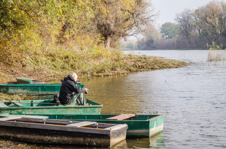 Wooden boat moored along the shore of the lake in water.の写真素材