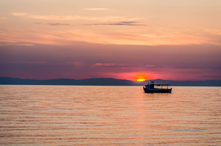 Fishing boat on the high seas, in the early morning hours in Leptokarya,Greece.の写真素材