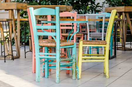 Wooden, multicolored chairs in a garden restaurant in Leptokarya, Greece.の写真素材