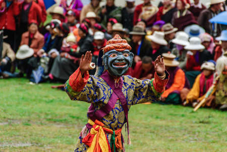 Juli Temple, lamas on mask of gods and dancing for prayer of peace and luck.