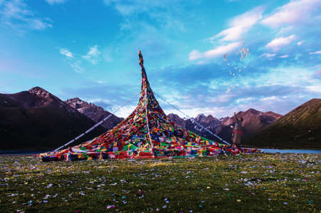 Nianbaoyuzhe,national park,morning,a tibetan man showered mani paper and pray beside the prayer tower.のeditorial素材