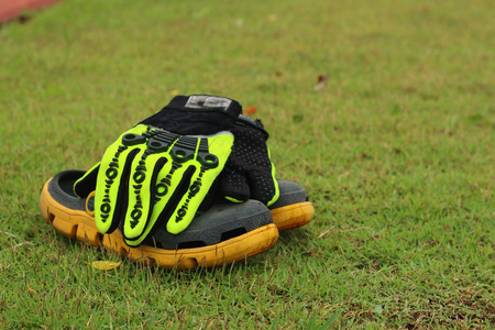 shoes and gloves football in green grass.の写真素材