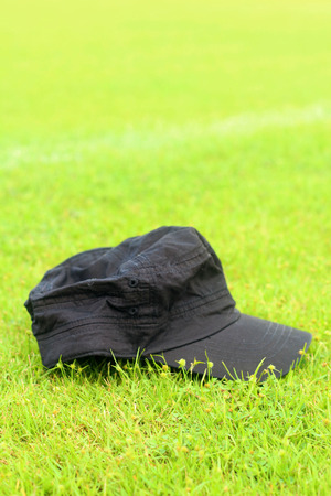 Cap lay on the the green grass.の写真素材
