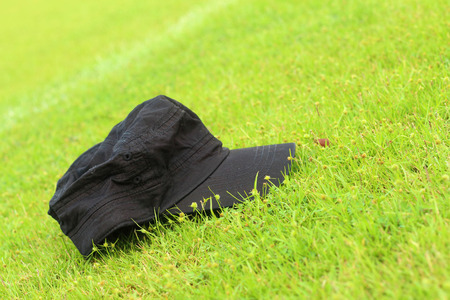 Cap lay on the the green grass.の写真素材