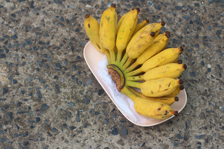 Bananas place on a pink plate on cementの写真素材