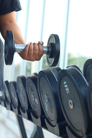 strong women hand takes a heavy dumbbell in gymの写真素材