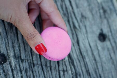 Magaroon in hand on a background of woodenの写真素材