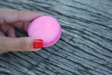 Magaroon in hand on a background of woodenの写真素材