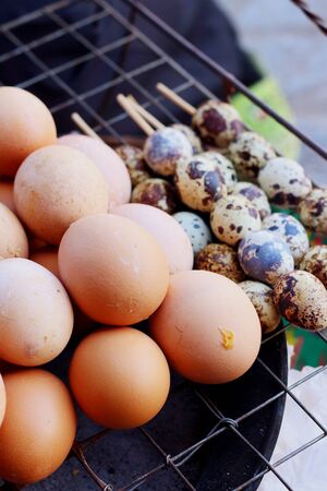 Grilled chicken eggs on the stove at the marketの写真素材
