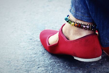 A woman wearing red shoes with jeans