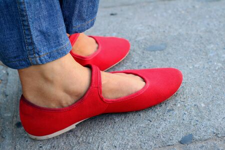 A woman wearing red shoes with jeans