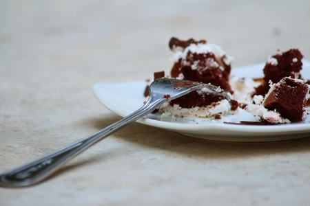 Chocolate cake on a white plate with a fork.の写真素材