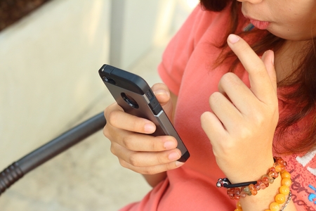 Women are using a phone at the parkの写真素材