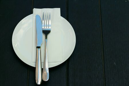 White dish with a knife and fork.