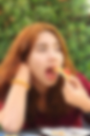 Blurred image of a woman eating pizzaの写真素材