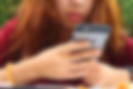 Blurred image of a woman using the phone.の写真素材
