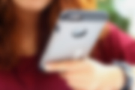 Blurred image of a woman using the phone.の写真素材