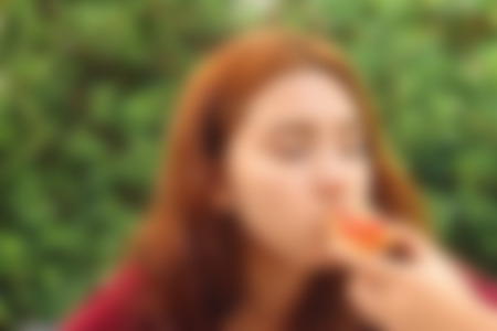 Blurred image of a woman eating pizzaの写真素材