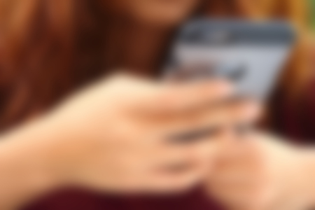 Blurred image of a woman using the phone.の写真素材