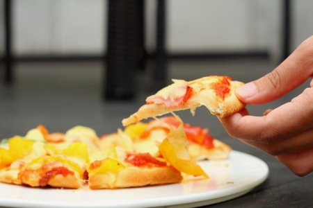 A women holding a pizza in handの写真素材