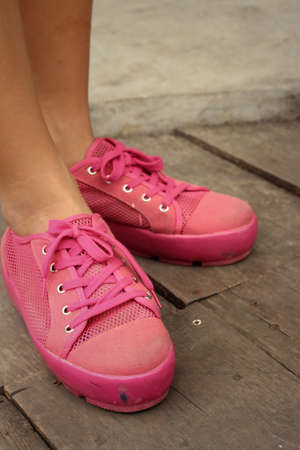 Pink shoes on a brown background at the park.