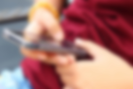 Blurred image of a woman using the phone.の写真素材
