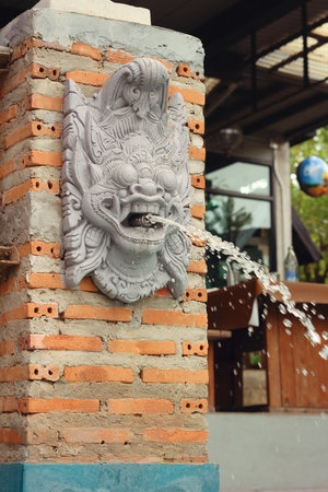 lion statue spitting water at the parkの写真素材