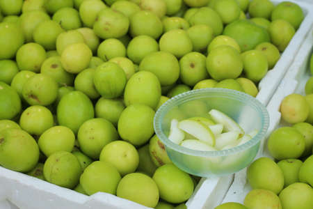 Green apples on a table at the marketの写真素材