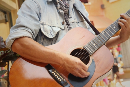The guitarist player standing at the park.