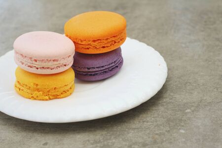 Macaron in white plates on the background of the cement.の写真素材