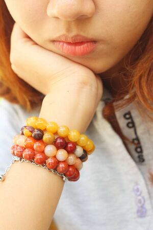 A young woman wearing a colorful bracelet.