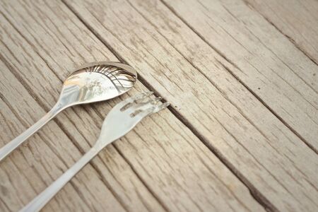 Spoon and fork on a background of brown wood.の写真素材