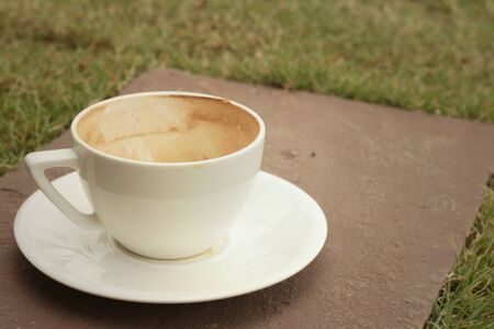 White coffee cup with saucer on the lawn.の写真素材