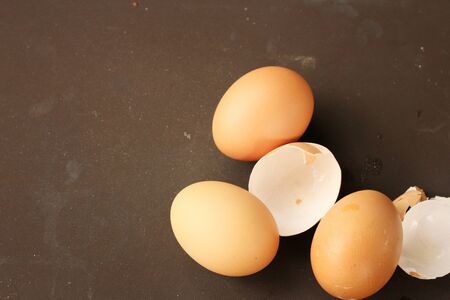 eggs and eggshell isolated on brown background
