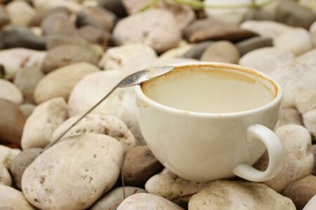 coffee cup wih tea spoon on stone background.の写真素材