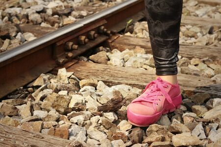 Woman wearing pink shoes at train station.の写真素材