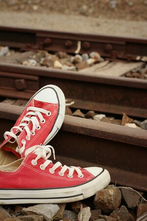 Red shoes leaning on the train tracks.の写真素材